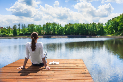 woman relaxing on a dock by a lake